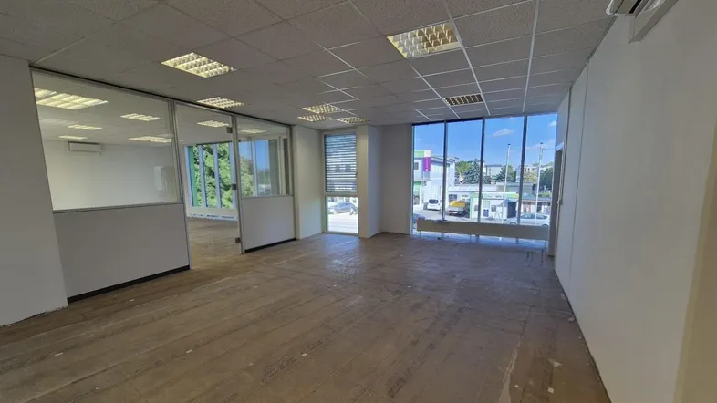 Geräumiges, unmöbliertes Büro mit großen Fenstern, Glasabtrennungen und abgehängter Decke, bereit für den Ausbau.
