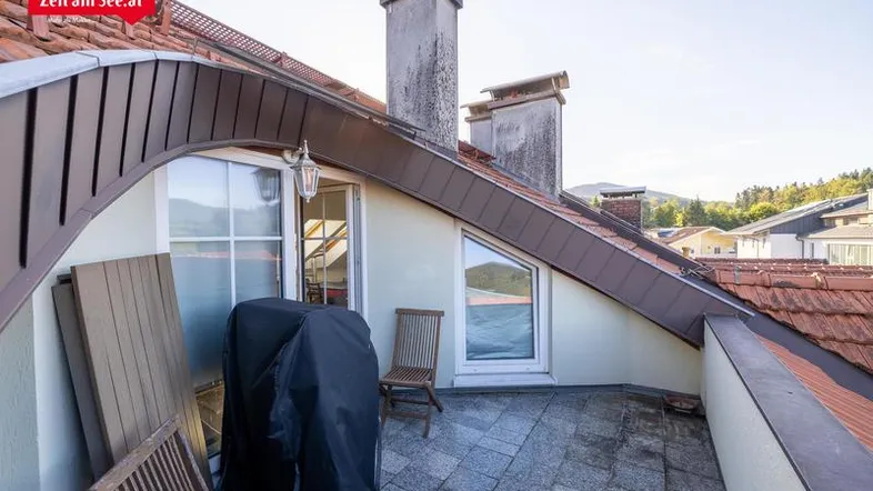 Geräumige Dachterrasse mit Fliesenboden, Grillbereich und Blick auf die Umgebung.