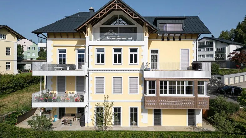 Seitenansicht des modernen Gebäudes mit mehreren Balkonen und Terrassenbereichen.