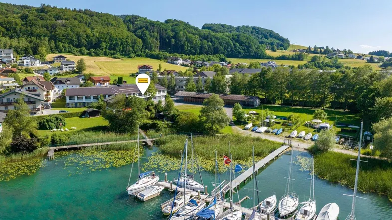 Luftaufnahme des Anwesens mit Blick auf den See, Boote und die umliegende grüne Landschaft.
