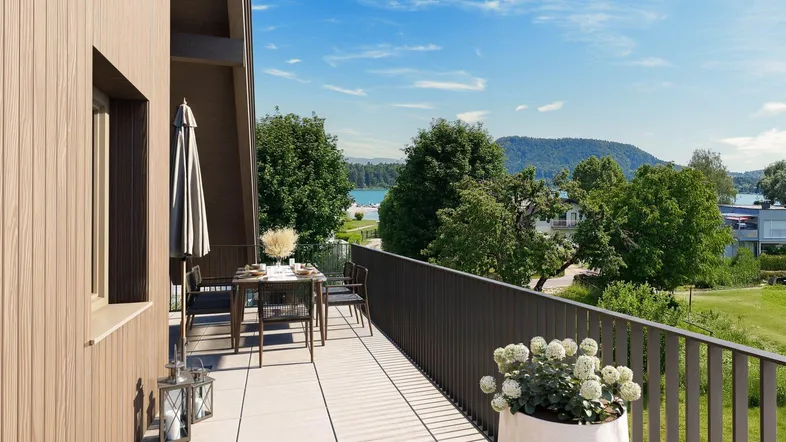Geräumiger Balkon mit Esstisch und Stühlen, bietet einen malerischen Blick auf den See und die umliegende Natur.
