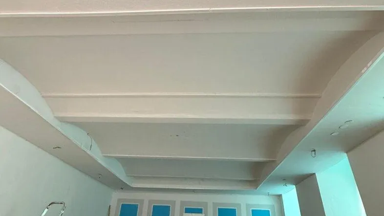 Großer, heller Innenraum mit hohen Decken und mehreren Fenstern, derzeit in einem unfertigen Zustand.
