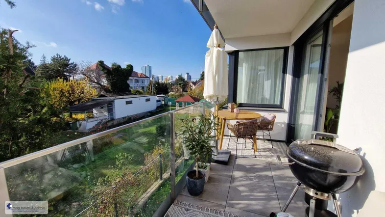 Geräumiger Balkon mit Stadtblick, Grill und Sitzgelegenheiten für entspannte Stunden im Freien.