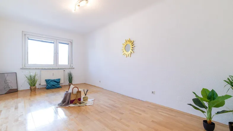 Helles Zimmer mit Parkettboden und weiß gestrichenen Wänden, bereit zur individuellen Gestaltung.