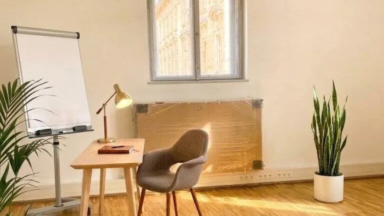 Helles Büro mit Holzparkett, großem Bogenfenster und moderner Deckenbeleuchtung.