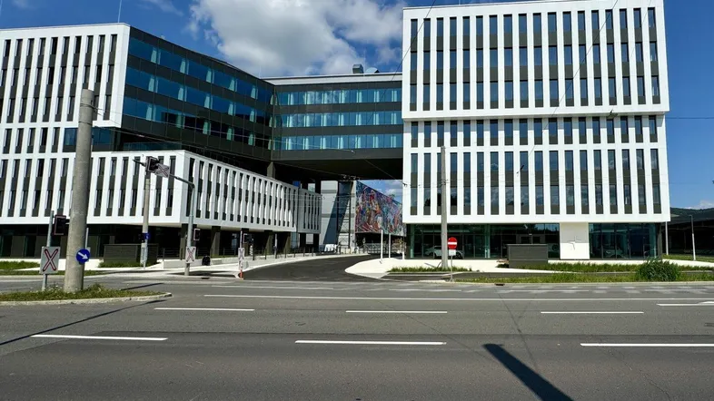 Modernes Bürogebäude mit markanter Architektur und Verbindungsbrücke unter blauem Himmel.
