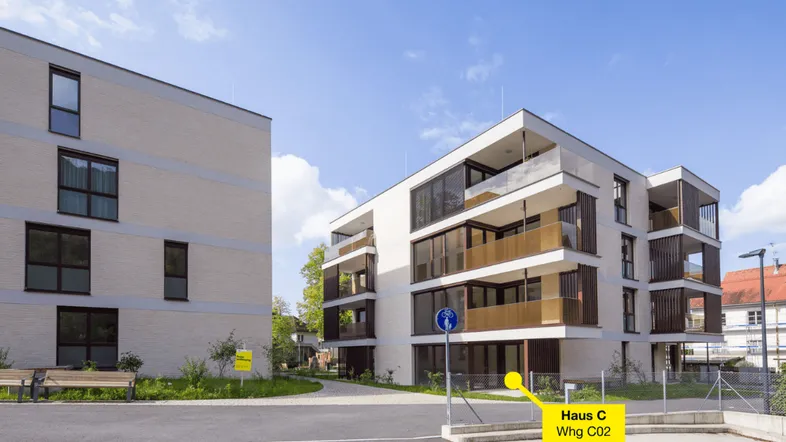 Moderne Wohngebäude mit klarer Architektur, großen Fenstern und Balkonen in einer gepflegten Anlage.