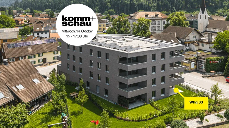 Luftaufnahme eines modernen Wohngebäudes mit Flachdach und Solaranlage in einer grünen Umgebung.