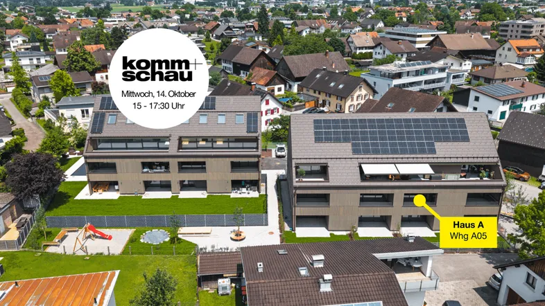 Luftaufnahme von modernen Neubauten mit Solaranlagen, umgeben von Grünflächen, Spielplatz und Bergblick in einer Wohngegend.