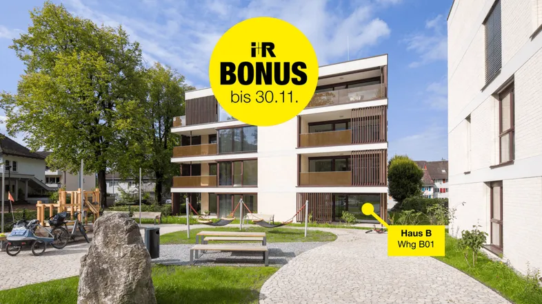 Modernes Mehrfamilienhaus mit Balkonen und einem gemeinschaftlichen Spielplatz im Grünen.