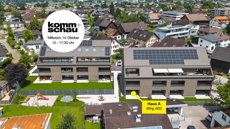 Luftaufnahme von zwei modernen Mehrfamilienhäusern mit Solaranlagen, umgeben von viel Grün und einem Spielplatz.