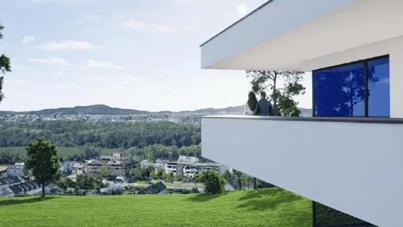 Moderne Architektur mit Balkon und weitem Blick über die grüne Landschaft und die Stadt.