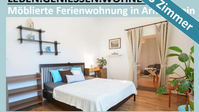 Helles Schlafzimmer mit Holzbett, modernen Regalen und offenem Zugang zu einem weiteren Wohnbereich.