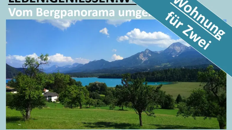 Malerischer Blick auf einen blauen See, umgeben von grünen Wiesen und majestätischen Bergen unter strahlendem Himmel.