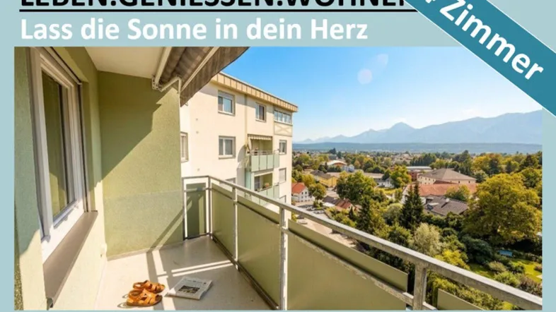 Sonniger Balkon mit Bergblick und Ausblick auf die umliegende Stadt und grüne Landschaft.