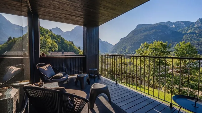 Geräumiger Balkon mit bequemen Sitzgelegenheiten und atemberaubendem Bergblick in sonniger Lage.