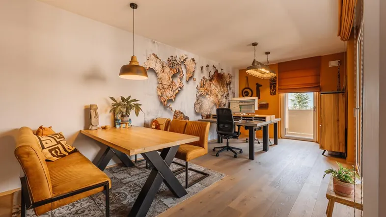Geräumiger Wohn- und Essbereich mit Holzboden, Weltkarten-Wanddekoration und Zugang zum Balkon.