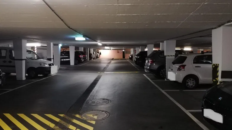 Geräumige Tiefgarage mit mehreren Stellplätzen und guter Beleuchtung für Fahrzeuge.