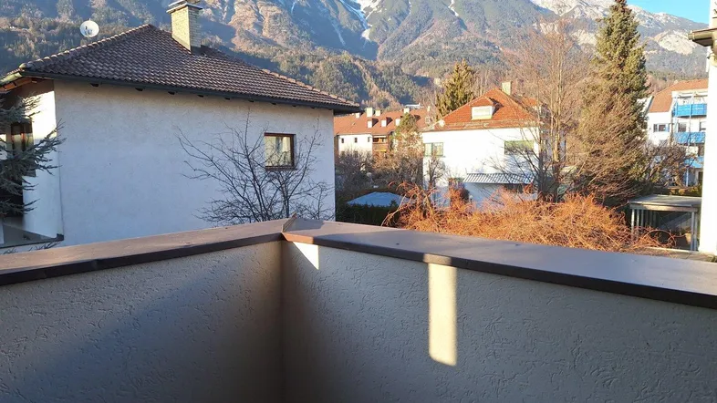 Balkon mit atemberaubendem Blick auf die umliegende Berglandschaft und weitere Wohnhäuser.