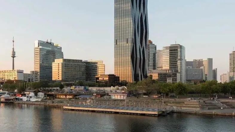 Beeindruckende moderne Hochhausarchitektur am Flussufer mit Stadtpanorama und klarem Himmel.