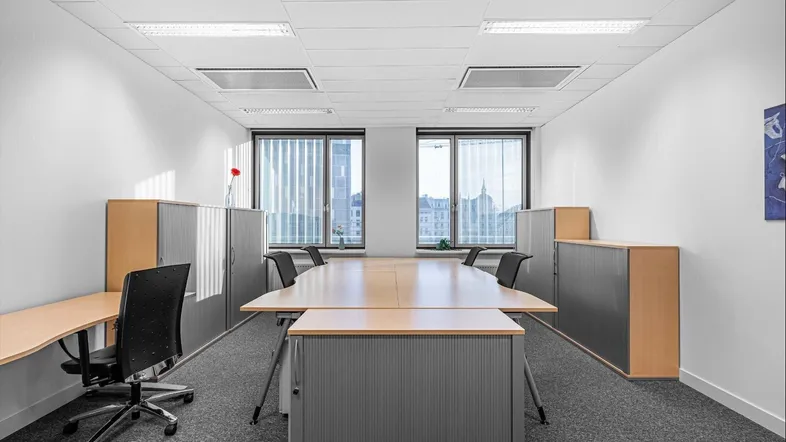 Geräumiges Büro mit großem Konferenztisch, modernen Schränken und Blick auf die Stadt.