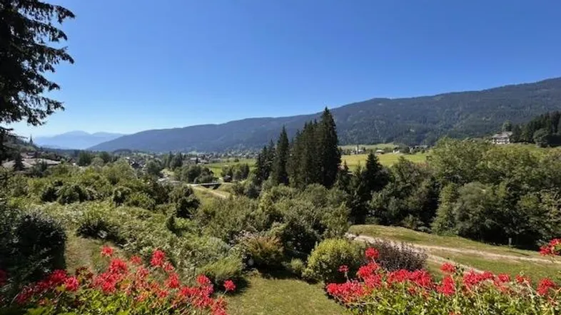 Panoramablick vom Balkon auf die grüne Landschaft und die umliegenden Berge.