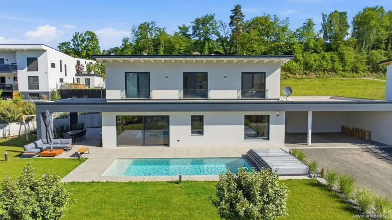 Modernes Einfamilienhaus mit Pool, großer Terrasse und gepflegtem Garten in sonniger Lage.