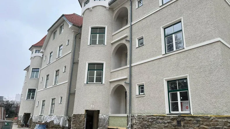 Neubau mit historisch anmutender Fassade, runden Türmen und Loggien, noch im Bau befindlich.