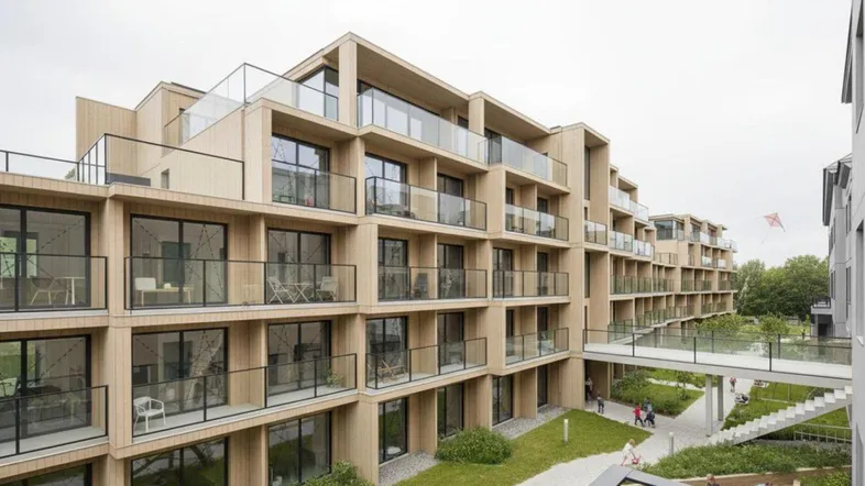 Moderne Wohnanlage mit Holzfassade, großzügigen Balkonen und begrüntem Innenhof.