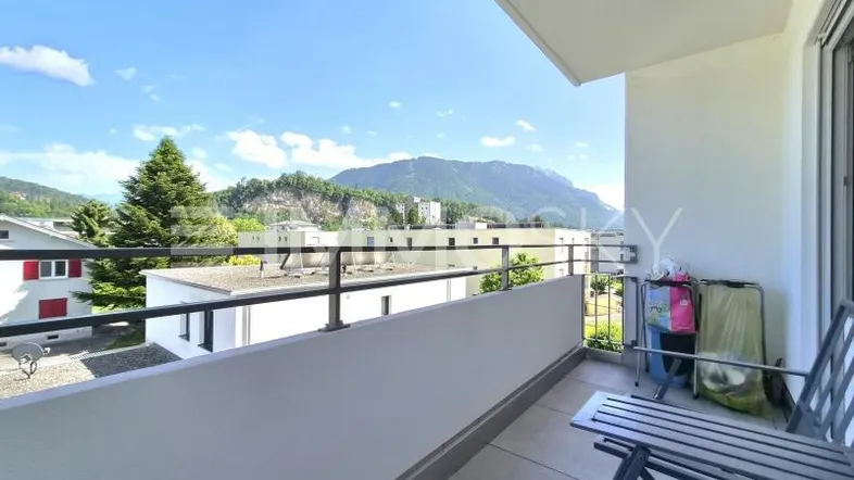 Heller Balkon mit Bergblick und Sitzgelegenheiten, ideal zum Entspannen im Freien.