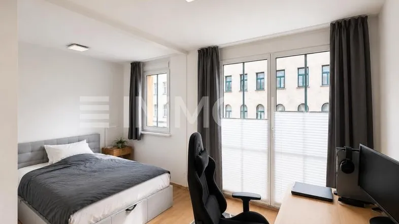 Helles Schlafzimmer mit modernem Bett, Schreibtisch und Blick auf die Stadt.