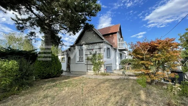 Historisches Einfamilienhaus mit Satteldach, Balkon und großem Gartenbereich.