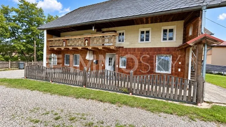 Traditionelles Haus mit Holzfassade, einem charmanten Balkon und Satteldach.