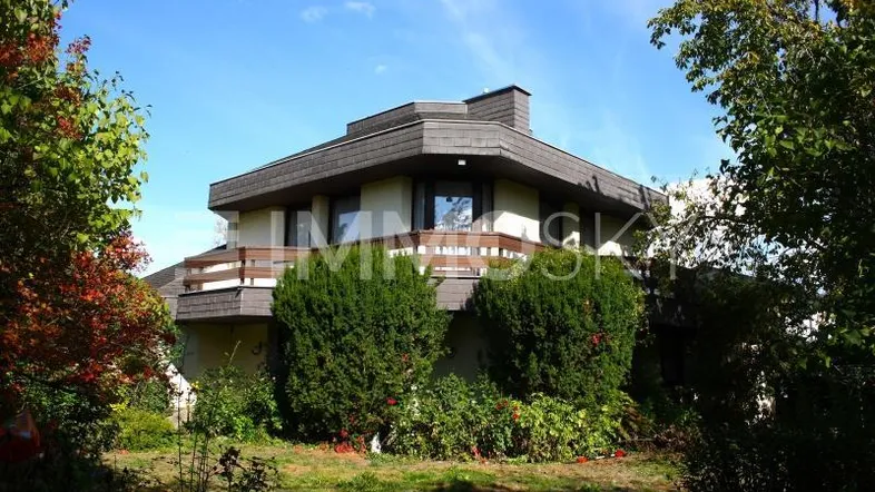 Geräumiges Einfamilienhaus mit mehreren Balkonen und einem gepflegten Vorgarten.