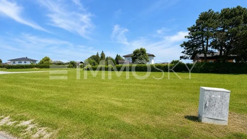 Großes, sonniges Grundstück mit weitem Blick auf die umliegende Landschaft und Wohnbebauung im Hintergrund.