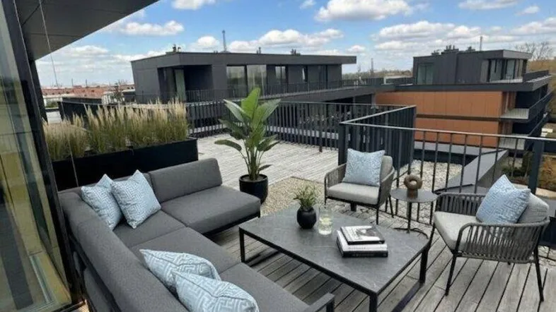 Moderne Dachterrasse mit bequemen Loungemöbeln und weitem Blick über die Umgebung.