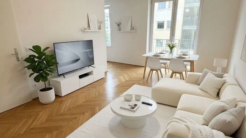 Helles Wohn- und Esszimmer mit Fischgrätparkett, moderner Einrichtung und großen Fenstern.