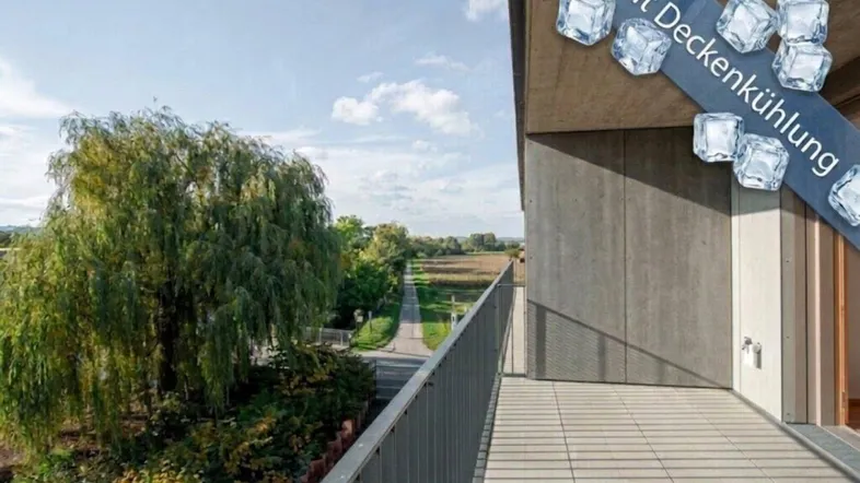 Geräumiger Balkon mit weitem Blick ins Grüne und Hinweis auf Deckenkühlung.
