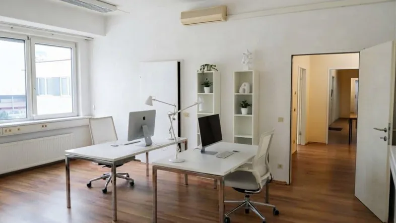 Helles Büro mit zwei Arbeitsplätzen, Holzfußboden und Klimaanlage, ideal für moderne Arbeitsumgebungen.