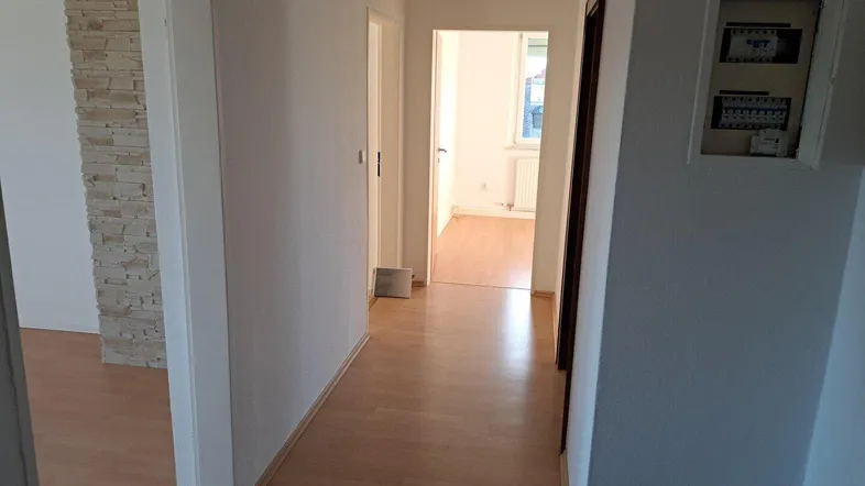 Heller Flur mit Laminatboden und Zugang zu weiteren Zimmern der Wohnung.