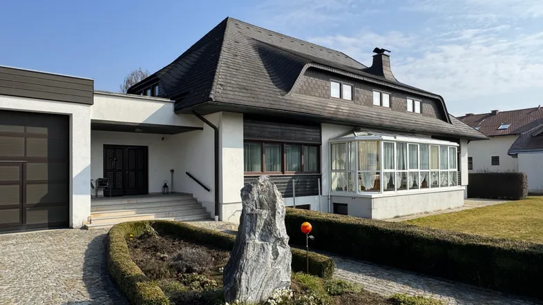 Großzügiges Einfamilienhaus mit Mansarddach, Wintergarten und integrierter Doppelgarage.