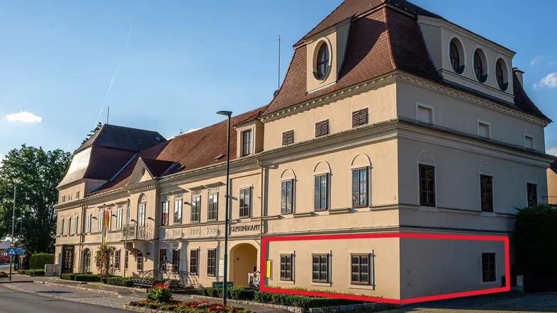 Historisches Gebäude mit markanter Architektur und Mansarddach, ein Teil ist rot umrandet.