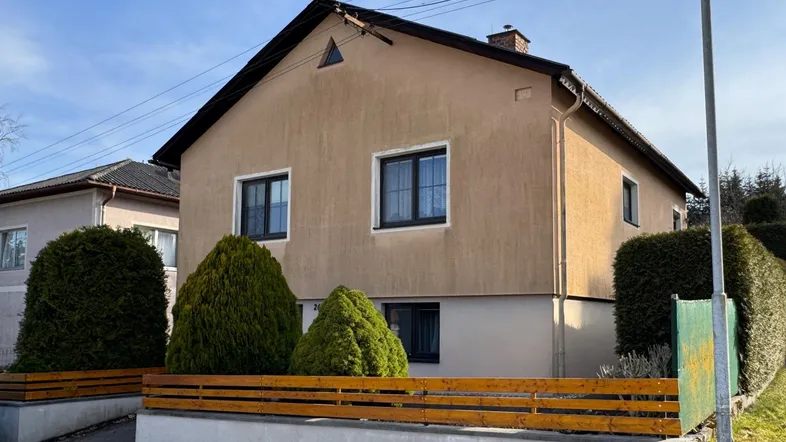 Ansicht des Einfamilienhauses von der Straße mit gepflegter Hecke und Vorgarten.