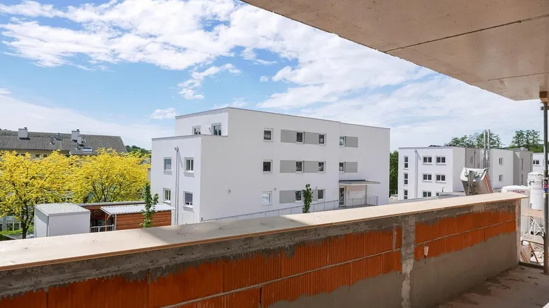 Blick auf ein im Bau befindliches Gebäude von einem Rohbau-Balkon aus.