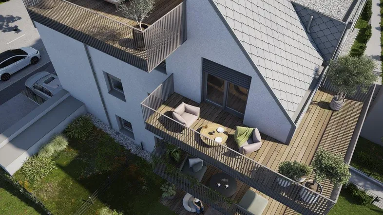 Moderne Wohnanlage mit mehreren Balkonen und Terrassen, umgeben von Grünflächen.