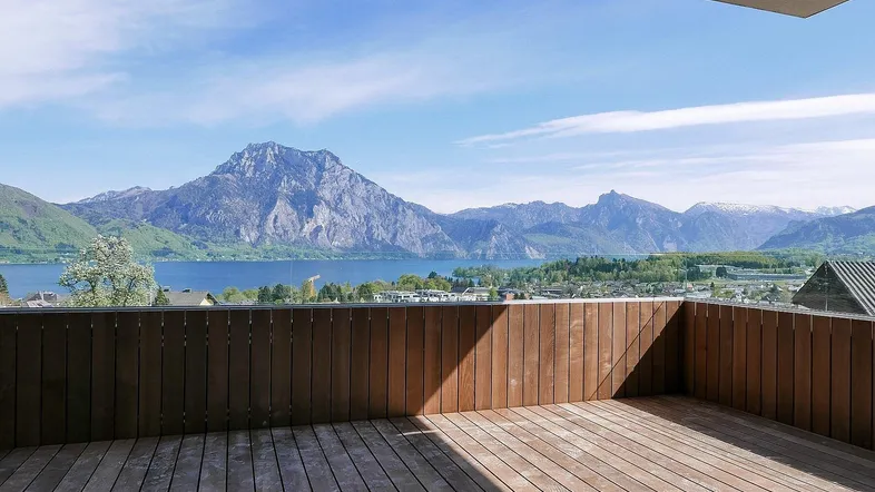 Geräumige Holzterrasse mit atemberaubendem Blick auf den See und die umliegenden Berge.