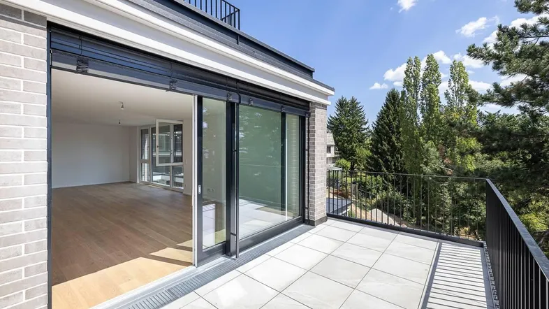 Geräumiger Balkon mit Fliesenboden und Blick auf die umliegende grüne Landschaft.