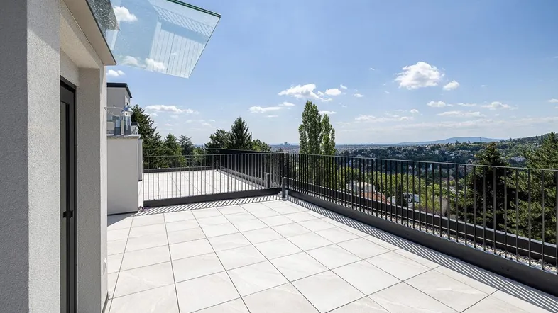 Große Dachterrasse mit weitem Panoramablick über die Stadt und die umliegende grüne Landschaft.