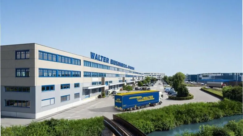 Luftaufnahme des Walter Business-Parks mit modernen Bürogebäuden, Zufahrtsstraße und einem Fluss mit Brücke.