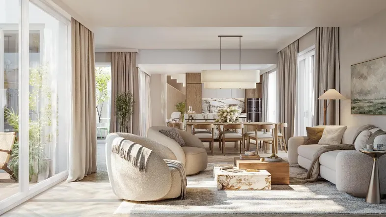 Helles, offenes Wohnzimmer mit großen Fenstern, modernen Möbeln und Essbereich im Hintergrund.